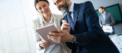 Two coworkers looking at a tablet