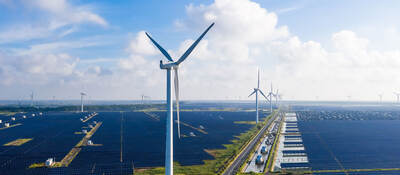 Solar power stations with wind turbines in distance