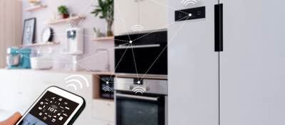 View of smart home from kitchen with appliances being operated by a mobile device.