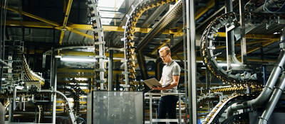 Engineer with laptop in a factory