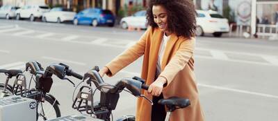 Woman in urban station with electric bicycles