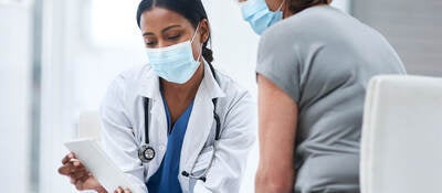 Doctor and patient looking at a tablet in an office. 