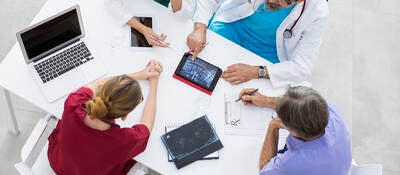 Medical team sitting and discussing at table.