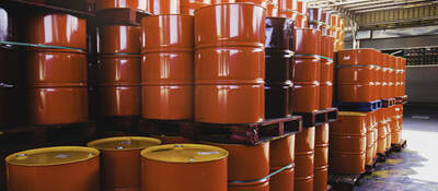 Stacks of red oil barrels in a warehouse