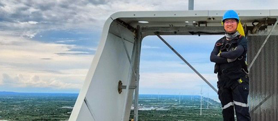 Engineer smiling at the top of a wind turbine