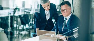 Two business colleagues collaborating over a laptop