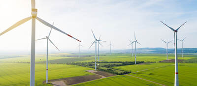 Sun shining over wind turbines on a wind farm