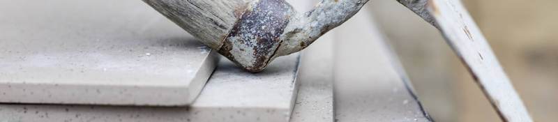 A trowel rests casually on a stack of cement tiles.