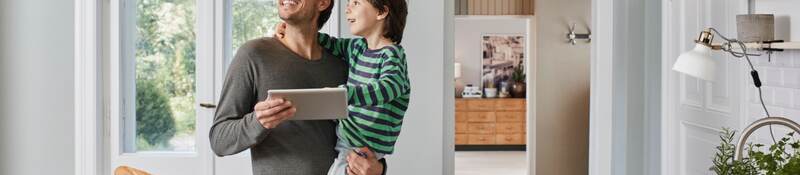 Father and son switching on smart lighting in the kitchen