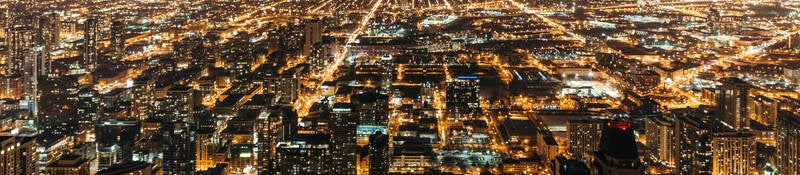 Cityscape at night with many lights from homes, businesses, roads