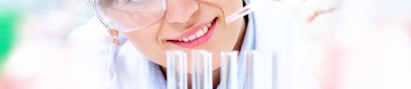 Female scientist dripping liquid into vials 