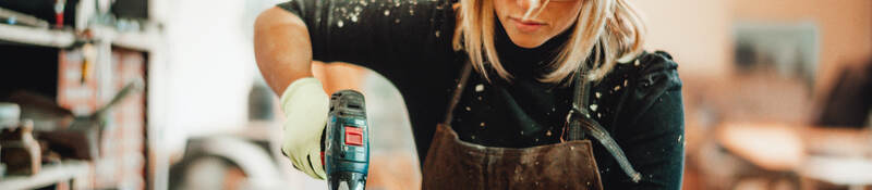 Female carpenter using power tool