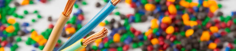 Plastic coated wire cable with plastic polymer granules in the background