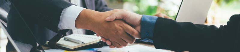 Business people shaking hands across a desk