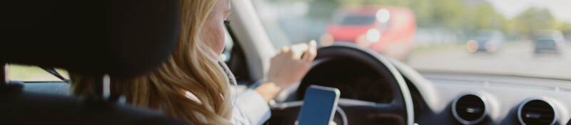 woman looking at a mobile phone in car