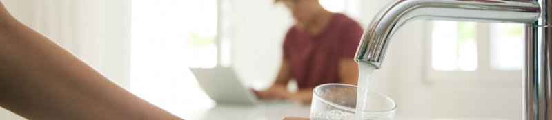 Person filling a glass with water