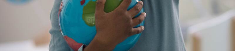 Child holding a toy ball.