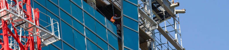 Lifting glass into place while constructing a commercial building