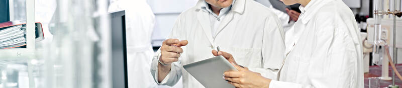 Two scientists working on a tablet in a lab