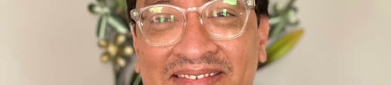 Close-up photo of Juan Calderon in blue short sleeved shirt. 