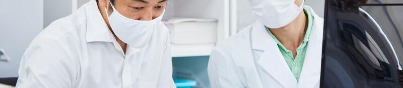 Life science researchers examining data on a laptop computer. 