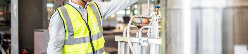 Worker operating a gas tank in a factory.  