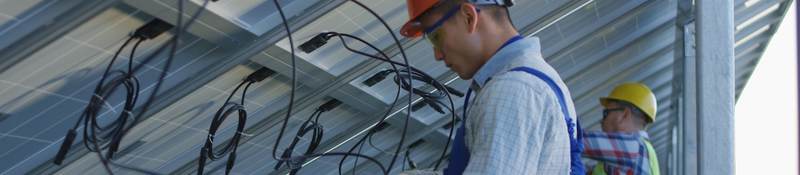 Workers connecting wires of solar panels