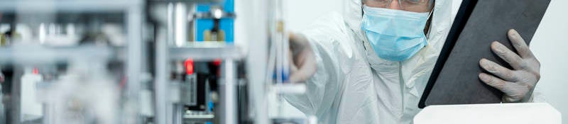 Shot of Caucasian Engineers using digital tablet for inspection quality of producing protective face mask in automated production line.