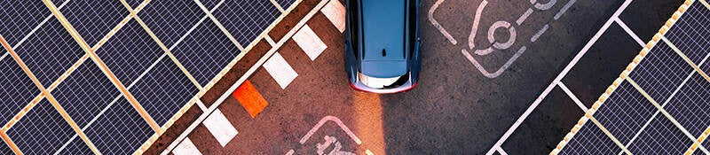 Overhead view of solar panels by an electrical vehicle charging area. 