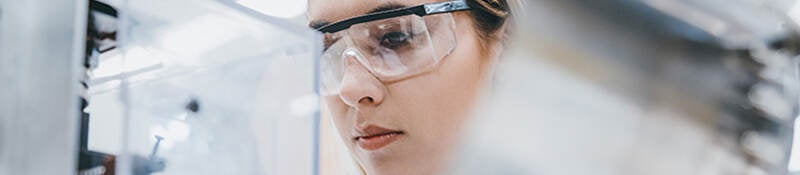 Scientist wearing safety goggles while reviewing samples