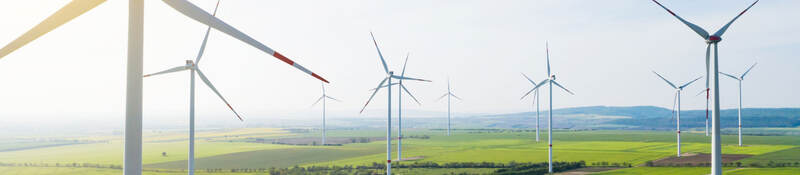 Sun shining over wind turbines on a wind farm