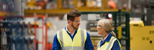 Workers collaborating in a warehouse with a tablet