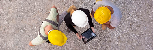 Workers on-site collaborating on a tablet