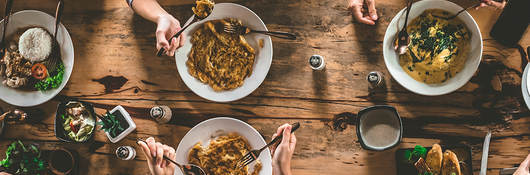 Bird’s-eye view of young people eating around a dinner table