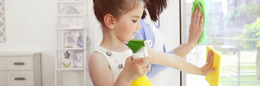 Girl helping her mother clean windows