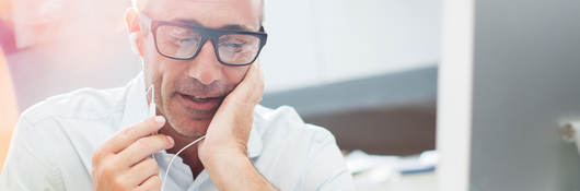 image of a man talking on a phone near a computer