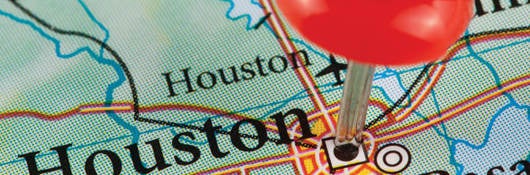 Map with Houston, Texas pinned by a thumb tack 