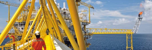 A worker walking on a platform of an offshore rig. 