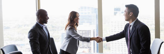 Workers shaking hands in a meeting