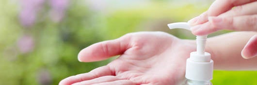 Female hand dispensing hand sanitizer onto open palm