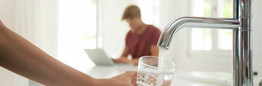 Person filling a glass with water