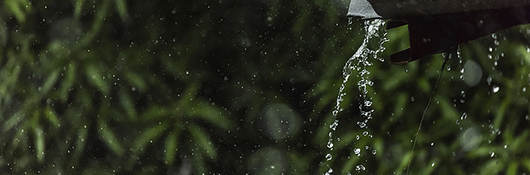 photo of rain draining off a tin roof