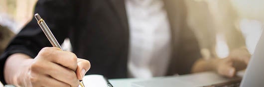 Photo of a person writing in a notebook