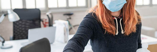 Photo of a woman cleaning a monitor