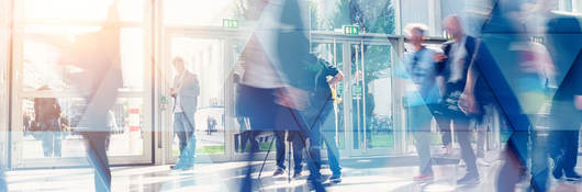 Business people walking in the lobby of a building with glass windows