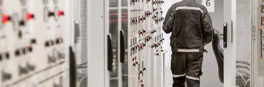 Engineer using protective relay and medium voltage switchgear in a bay control unit.