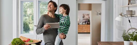 Father and son switching on smart lighting in the kitchen