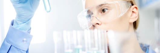 Young woman working in laboratory, handling test tubes