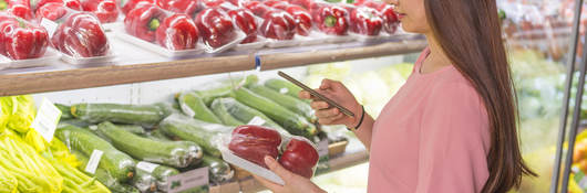 Customer in a grocery store scanning a QR code