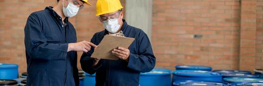 Men in PPE working in chemical warehouse